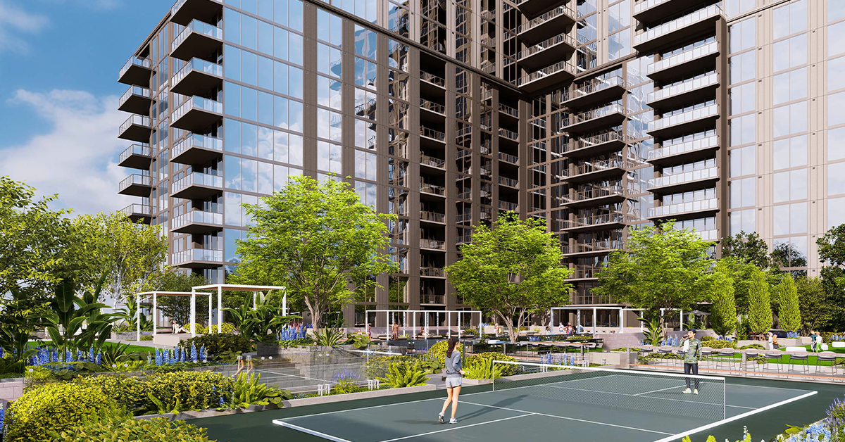 Residents play pickleball on an outdoor court surrounded by landscaped seating and modern buildings.