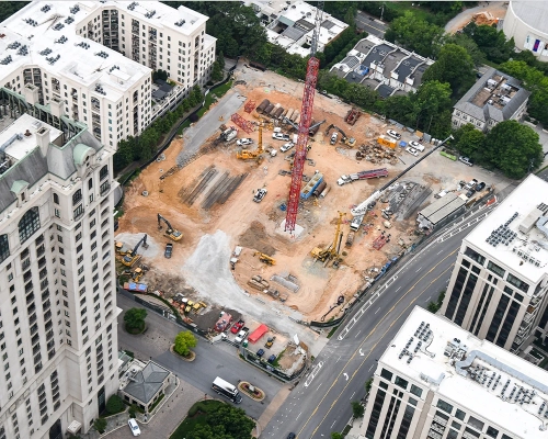 High-angle aerial view of the Elyse Buckhead construction site framed by Buckhead towers, streets and nearby buildings.